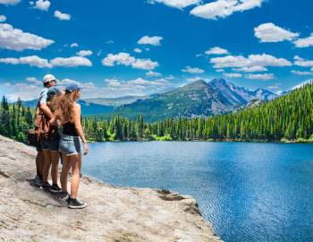 family looking at lake and mountains in Colorado on sunny day