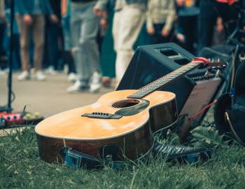 guitar on grass propped on a speaker