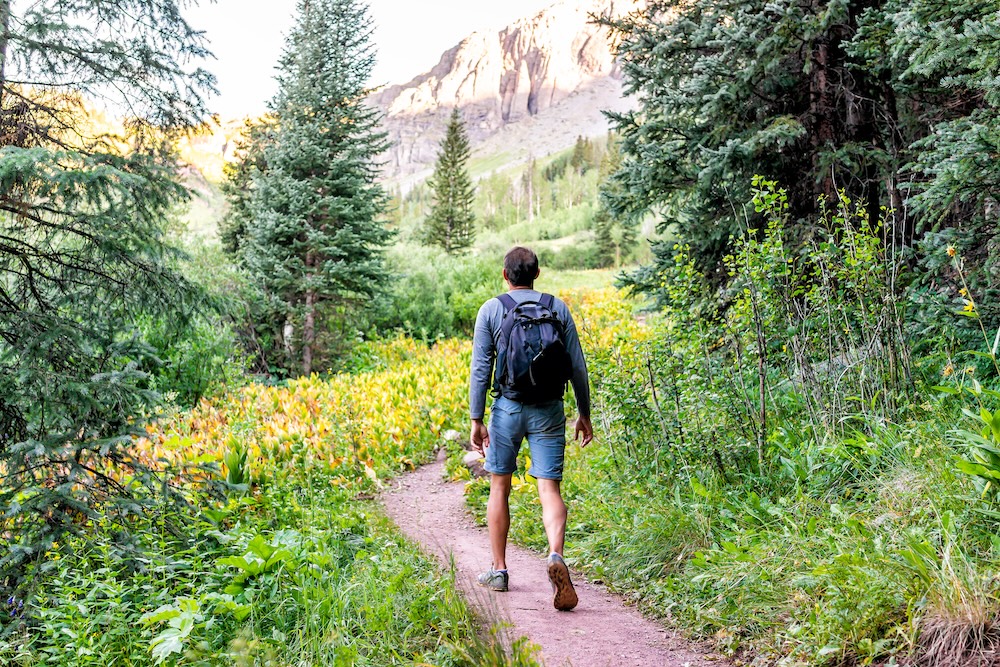 man hiking on a mountain trail in colorado
